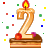 This gif animation shows a lit candel in the shape of a number 2 , with sparkles flickering in the background