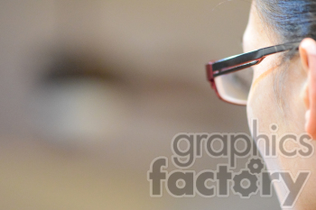 Close-up view of a person's head wearing red-framed glasses, focused on the glasses frame and the back of the head.