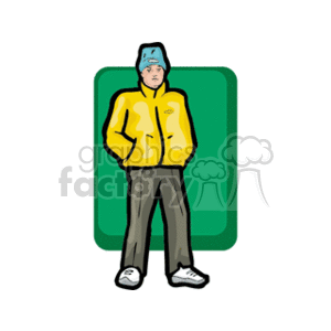 A boy in a yellow jacket with his hands in his pockets wearing a blue stocking cap
