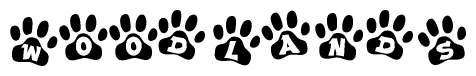 The image shows a series of animal paw prints arranged in a horizontal line. Each paw print contains a letter, and together they spell out the word Woodlands.