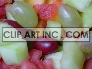 A close-up image of a colorful fruit salad containing grapes, watermelon, and other mixed fruits.