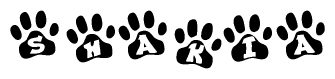 The image shows a row of animal paw prints, each containing a letter. The letters spell out the word Shakia within the paw prints.