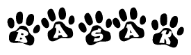 The image shows a row of animal paw prints, each containing a letter. The letters spell out the word Basak within the paw prints.