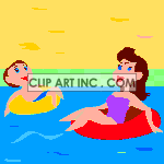 A mother and son floating on innertubes at the lake