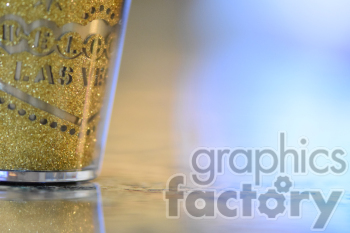 A close-up photo of a golden glittery Las Vegas souvenir cup on a reflective surface with a blurred background.