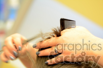 Close-up of a hairstylist's hands cutting hair using a comb and scissors. The stylist has glittery nail polish and a ring on one finger.