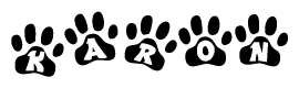 The image shows a series of animal paw prints arranged in a horizontal line. Each paw print contains a letter, and together they spell out the word Karon.