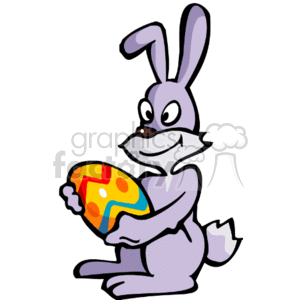 This clipart image features a cartoon rabbit, or Easter Bunny, happily holding a brightly painted Easter egg. The bunny is in a sitting position, and the décor on the egg includes multiple colors and patterns.