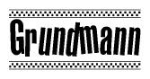 The image contains the text Grundmann in a bold, stylized font, with a checkered flag pattern bordering the top and bottom of the text.