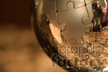 A close-up image of a metallic globe-shaped jigsaw puzzle with golden reflections.