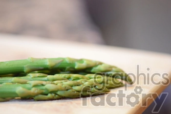 Close-up image of fresh green asparagus spears on a wooden surface.