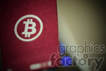 A close-up image of a red surface featuring a white Bitcoin logo.