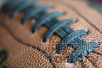 Close-up image of a football's stitching and textured surface.