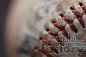 A close-up image of a worn baseball showing detailed red stitching and a textured surface.