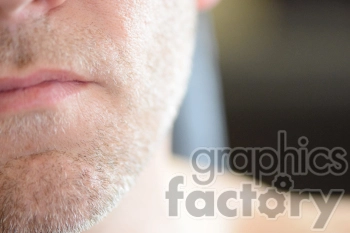 Close-up of a man's face showing the lips and chin with stubble.