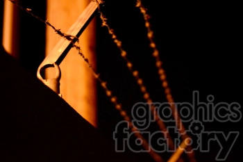 Close-up image of barbed wire fences illuminated by a warm light in the darkness.
