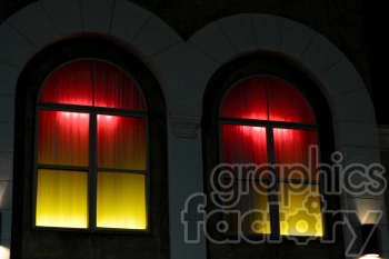 Clipart image of two arched windows with red and yellow gradient lighting emanating from behind curtains.