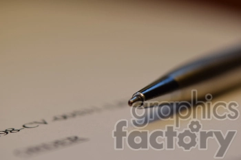 The photo shows a pen laying on top of a document, suggesting the act of writing or signing on the document.
