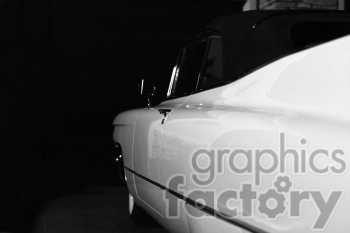 A black and white photograph of a classic car focusing on the side profile, emphasizing its sleek and shiny surface.