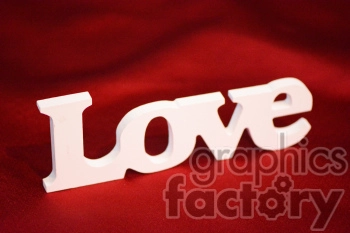 A 3D white text sign spelling out 'Love' on a red background.