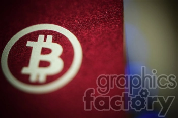 Close-up image of the Bitcoin logo on a red textured surface.