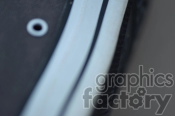 A close-up, slightly blurred image of a shoe, focusing on the side with visible eyelets and part of the sole.