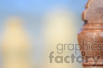 A close-up, blurred image focusing on a wooden chess piece with an abstract background.