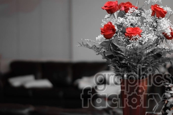 A bouquet of red roses arranged in a red vase, sitting against a minimally blurred background, showcasing a monochromatic environment with the vibrant red roses and vase highlighted.