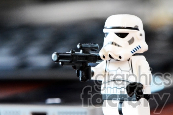 Close-up of a toy figure resembling a Stormtrooper from Star Wars, holding a blaster gun.