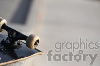Close-up image of a skateboard's wheel and truck on a railing with a blurred background.