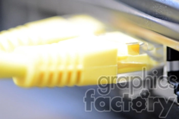 Close-up image of a yellow ethernet cable connected to a port.