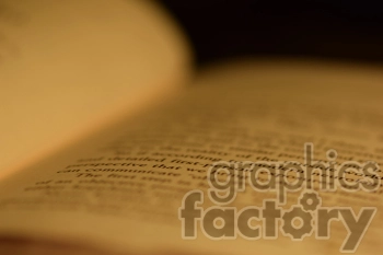 A close-up, blurred image of an open book with visible text.