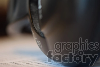 A close-up image focusing on the edge of a computer mouse, resting on a sheet of paper containing printed text. The depth of field is shallow, blurring the background.