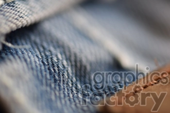 Close-up image of blue denim fabric with visible stitching and texture.