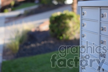 A close-up of a community mailbox with multiple compartments and numbers outdoors.