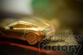 Close-up image of a golden toy car with a blurred background, showcasing intricate details of the miniature vehicle.